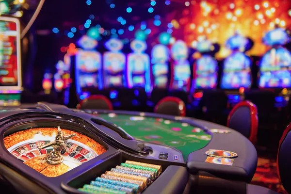 A man celebrating a winning moment on his laptop while gaming symbols float around him, capturing the excitement of SAGISAGPH games.